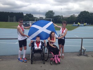 Four Scottish Para athletes celebrate medals with a Saltire flag